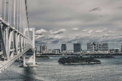 View of cityscape by sea against sky