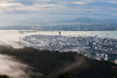 Aerial view of cityscape and mountains against sky