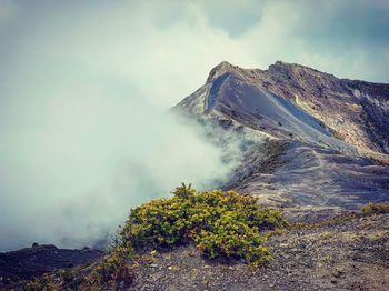 Smoke emitting from volcanic mountain against sky