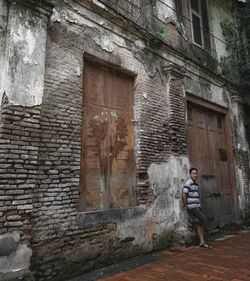 Full length of man standing against old building