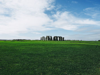 View of grassy field against cloudy sky