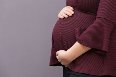 Midsection of woman standing against white background