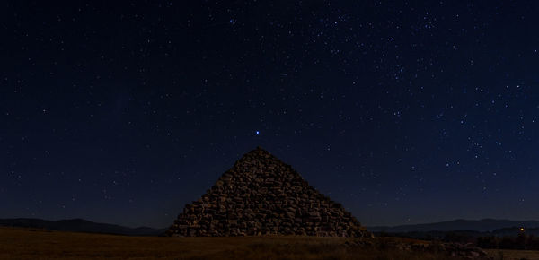 Mountain against star field sky at night