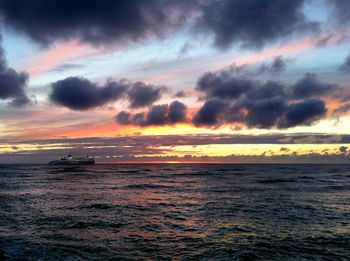 Scenic view of sea against dramatic sky during sunset