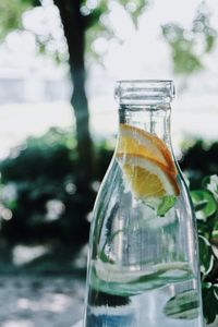 Close-up of lemon slices and drink in glass jar outdoors