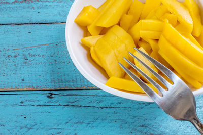 High angle view of yellow slices in bowl on table