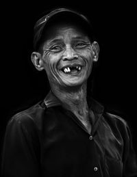 Portrait of smiling man against black background