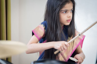 Girl in sari playing drum