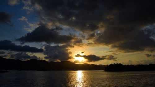 Scenic view of sea against dramatic sky during sunset