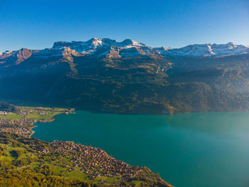 Scenic view of lake and mountains against blue sky