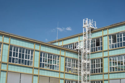 Low angle view of modern building against blue sky