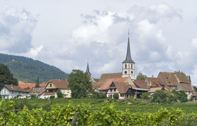 Panoramic view of trees and houses against sky