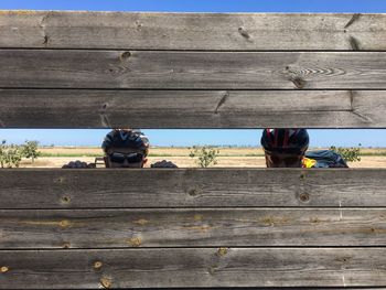 People relaxing on bench against wall