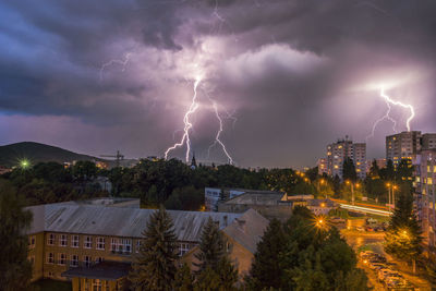 Lightning over illuminated buildings in city at night