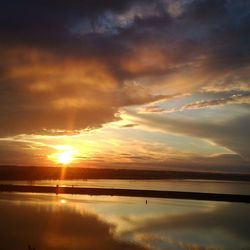 Scenic view of sea against cloudy sky at sunset