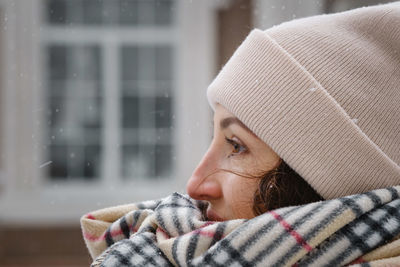 Happy middle age woman catching snowflakes in the city outdoors. relaxed emotional person closeup 