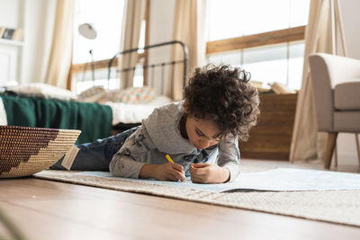 Boy writing in paper at home