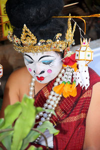 Man with painted face sitting during traditional ceremony