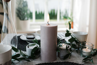 Large candle on a romantic dinner table at home