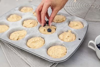 Cropped hand of woman preparing cookies in baking sheet