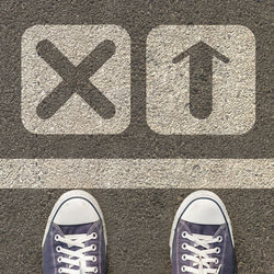 Low section of person standing by road sign on street