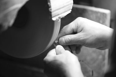 Cropped hands of person polishing equipment in workshop