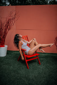 Woman lying down while sitting outdoors