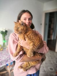 Portrait of young woman with cat