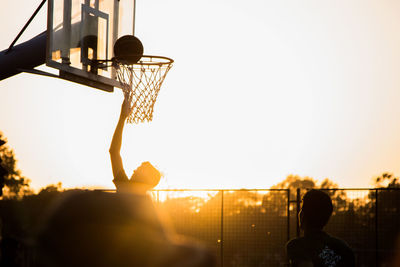 Silhouette basketball hoop against sky during sunset