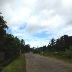 Road amidst trees against sky