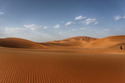 Sand dunes in desert against sky