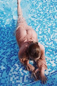High angle view of woman relaxing in swimming pool