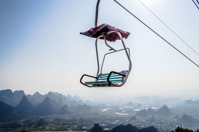 Low angle view of overhead cable car against sky