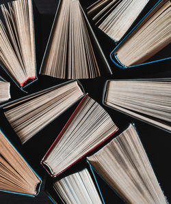 Parted books next to each other top view. background from multicolored old books.