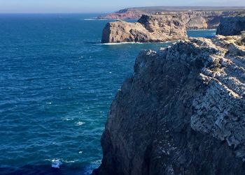 Scenic view of sea by rock formation against sky