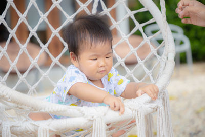 Cute baby girl looking at fence