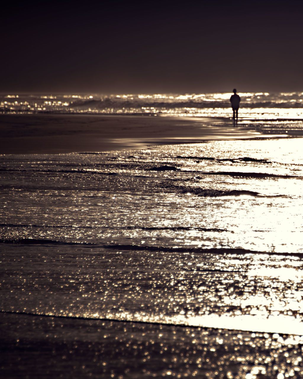 SILHOUETTE PERSON WALKING ON BEACH AGAINST SKY DURING SUNRISE