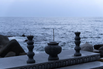 Close-up of pebbles on sea against clear sky