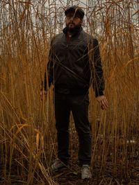 Man standing by tree on field in forest