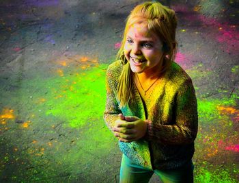 Portrait of a smiling young girl covered in paint powder