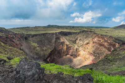 Volcanic crater at izu oshima island against cloudy sky