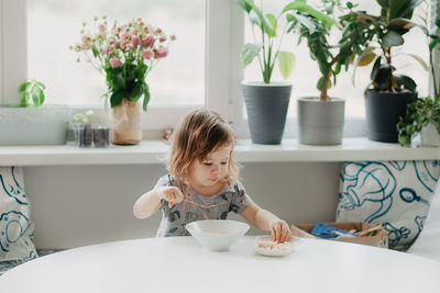 Portrait of cute girl sitting on table