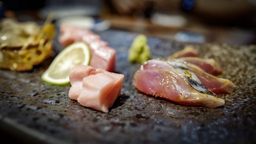 Close-up of meat and lemon on slate