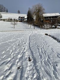 Snow covered field by building