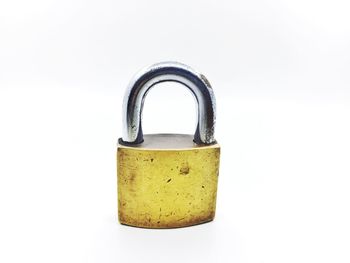 Close-up of padlocks on metal against white background