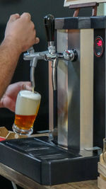 Midsection of man holding beer glass