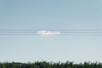 Low angle view of electricity pylon against clear sky