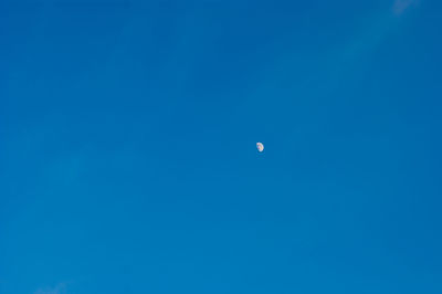 Low angle view of moon against blue sky