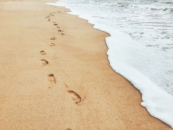 Footprints on sand at beach