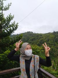 Full length of woman standing by plants against sky